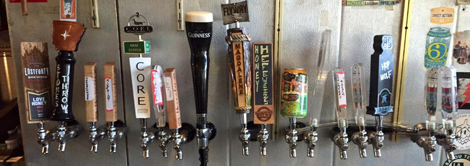 A series of beer taps at a bar.